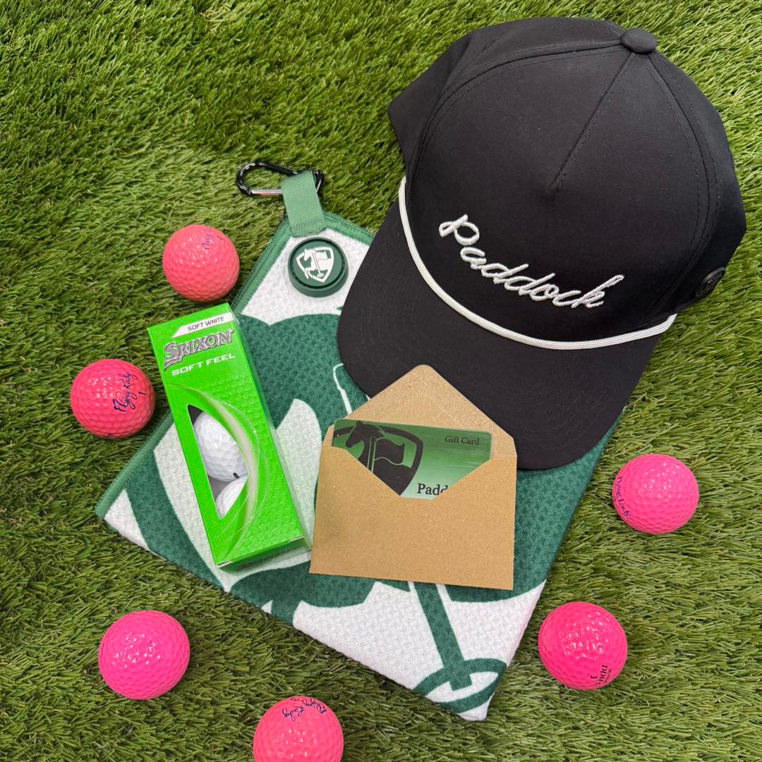 Golf cap, golf balls, and golf towel on a grass surface