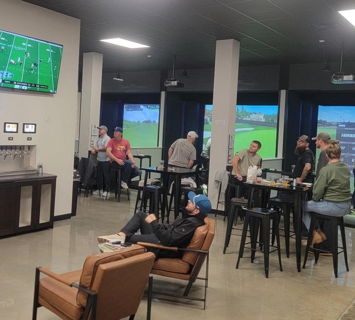 People watching sports on multiple screens in a casual setting