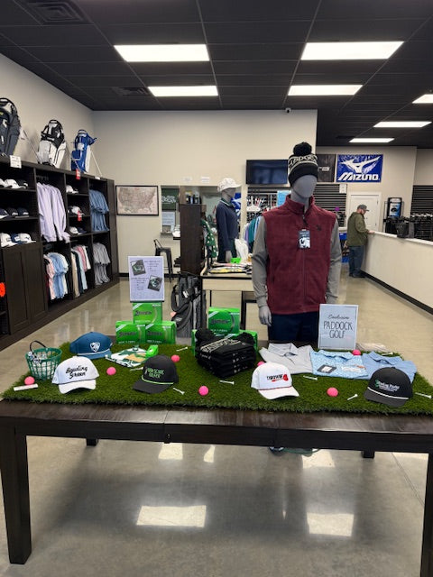 Display of sports merchandise including hats, shirts, and a mannequin in a store setting.